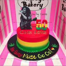 Bob Marley Rasta themed cake with 3 colour butter icing stripes, 2D mounted photo poster of Bob Marley on top and cannabis leaves on cake board