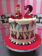 Tall single tier Circus themed cake with personalised name design, bunting and 3D figurine topper of clown next to 3D number 2